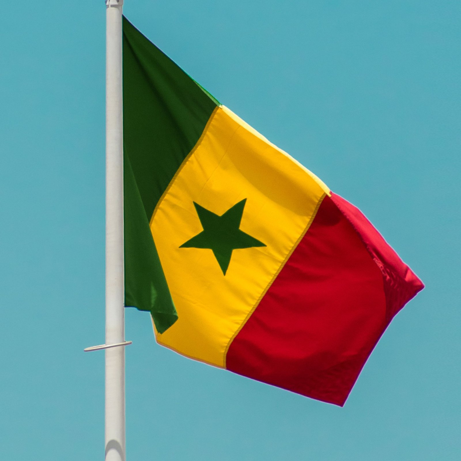 drapeau flottant du Sénégal dans le ciel bleu